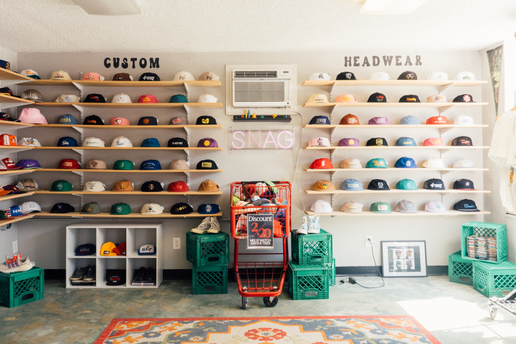 Wall of colorful snapbacks and custom hats in SNAG Collective shop, showcasing vintage-inspired designs and limited runs