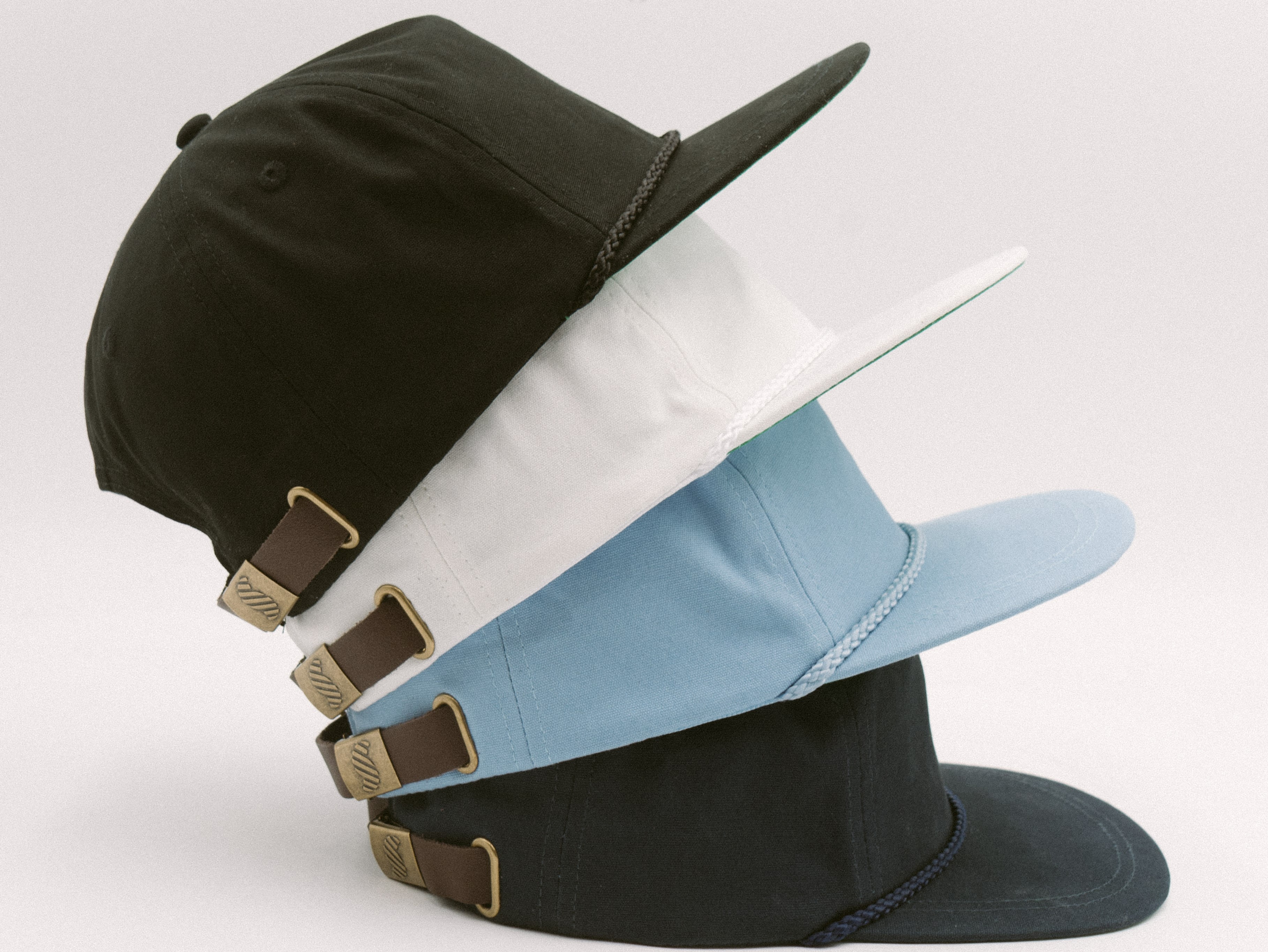 Stacked SNAG Collective snapback hats in neutral tones, highlighting custom design, structured fit, and premium craftsmanship