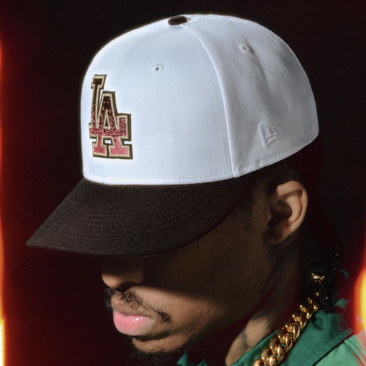 Close-up of model wearing white LA fitted cap with dark brim and gold chain, showcasing Hat Club proven streetwear style